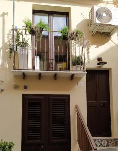 un edificio con balcone e piante sopra di La Nicuzza-#historicalhouse a Agrigento