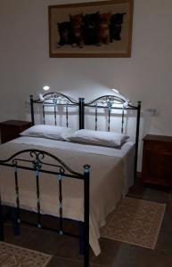 1 cama con marco negro y sábanas y almohadas blancas en Casa Toloi, en Dorgali