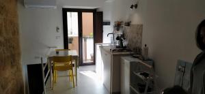 a kitchen with two yellow chairs and a stove at La Nicuzza-#historicalhouse in Agrigento
