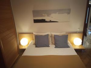 sypialnia z łóżkiem z 2 lampami w obiekcie Plateia Apartments (Katerina) w mieście Ajos Nikolaos