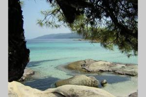 widok na plażę z kamieniami w wodzie w obiekcie Plateia Apartments (Katerina) w mieście Ajos Nikolaos