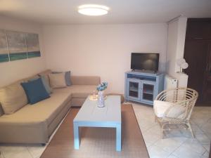 salon z kanapą, stołem i telewizorem w obiekcie Plateia Apartments (Katerina) w mieście Ajos Nikolaos