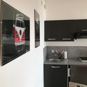 a kitchen with a painting of a train on the wall at Studio Meublé Vue Mer in Le Havre