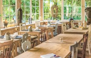 un restaurant avec des tables et des chaises en bois ainsi que des fenêtres dans l'établissement Pet Friendly Home In Simpelveld With Outdoor Swimming Pool, à Simpelveld