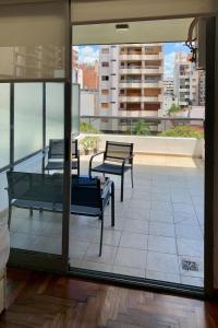 two benches on a balcony with a view of a city at Ayres de Córdoba, Gran Terraza, Excelente Ubicación in Cordoba