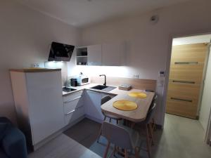 a small kitchen with a small table and chairs at Les pieds dans l'eau in Trouville-sur-Mer