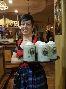 a woman is holding a tray of milk mugs at Hotel Vittoria in Riva del Garda