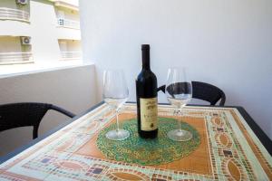a bottle of wine and two wine glasses on a table at 500 Meters from Grate Beach, App 10 in Ulcinj