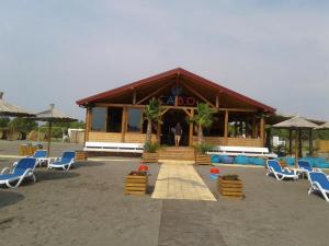 a building with chairs and a man standing in front of it at Villla Elkom, App 10 in Ulcinj