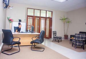 a woman sitting at a desk in a waiting room at Angel Boutique Hotel in Maputo