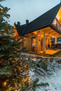 a log cabin with a christmas tree in front of it at Przedsionek Tatr in Zakopane