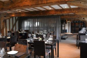 塔登汉姆Tuddenham Mill Luxury Hotel的用餐室配有桌椅和酒杯