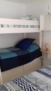 1 Schlafzimmer mit 2 Etagenbetten und einem blauen Kissen in der Unterkunft LES TILLEULS in Riez