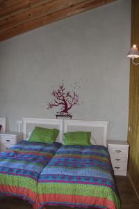 1 dormitorio con 1 cama con un árbol en la pared en Eco Urbion, en Duruelo de la Sierra