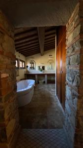 a large bathroom with a tub and a stone wall at Vogue Hotel Arezzo in Arezzo