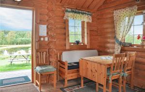 a dining room with a table and chairs in a log cabin at 2 Bedroom Lovely Home In Sunne in Sunne