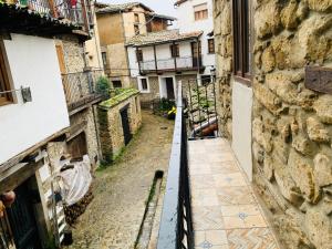 Un callejón en un casco antiguo con edificios. en LA CASA REBONITA, en Candelario