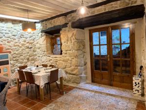 a dining room with a table in a stone building at LA CASA REBONITA in Candelario