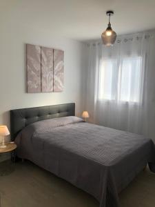 a bedroom with a bed and a pendant light at L'Alivu in Ajaccio