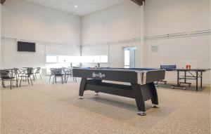 a ping pong table in a room with tables and chairs at Feriehotel Tranum Klit in Brovst