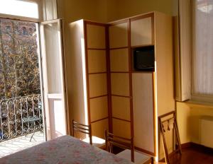 a room with a book shelf and a television at Hotel Giglio in Salsomaggiore Terme