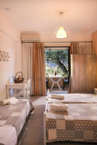 a bedroom with two beds and a room with a window at Marilena Apartments & Studios in Dassia