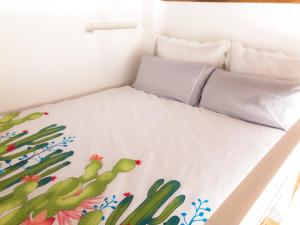 Cama en habitación con manta de cactus en Pasaje de Amores, en Sevilla