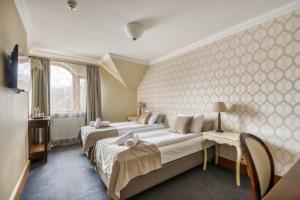 Cette chambre comprend 2 lits et une fenêtre. dans l'établissement American House Baletowa, à Varsovie