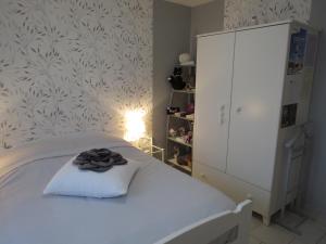 1 dormitorio con 1 cama blanca y armario blanco en Chambre d'hôtes La Clé du Bonheur, en Manthelon