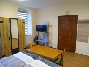 a bedroom with a bed and a table and a tv at Ferienwohnung Schleich in Starkenberg