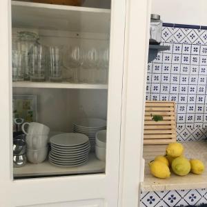 a cabinet with plates and bowls and lemons in it at Ca' del Sale 97 in Marsala