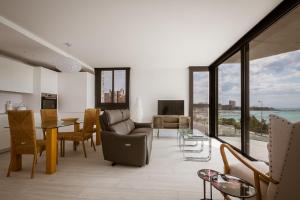 een woonkamer met een bank en een tafel en stoelen bij Modern sea front Sunny Beach in Alicante