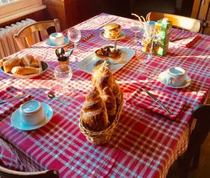 a table with a red and white checkered table cloth at Chambres chez l'habitant et table d'hôtes Crocq "le vieil hôtel" in Crocq +12 photos