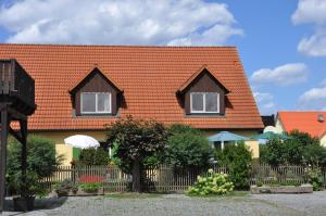 een huis met een oranje dak en twee ramen bij Ferienwohnung Gäste Oase in Bad Windsheim