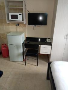 a room with a desk with a microwave and a computer at Nairobi west suite in Nairobi