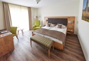 Un dormitorio con una cama y una mesa y sillas. en Fetzers Landhotel, en Ingelheim am Rhein