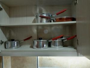 a shelf with pots and pans in a kitchen at Nairobi west suite in Nairobi