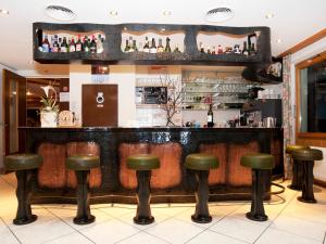 a bar with leather stools in a restaurant at Hotel Ambiente in Saas-Fee
