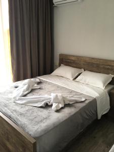uma cama grande com lençóis brancos e almofadas em Cottages Ureki em Ureki