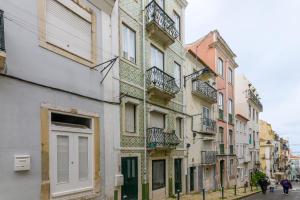 uma fila de edifícios numa rua com pessoas a andar pela rua em Sant´Ana Apartment em Lisboa