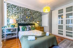 um quarto com uma cama e uma parede com espelhos em Sant´Ana Apartment em Lisboa