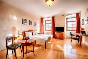 um quarto com uma cama, uma mesa e cadeiras em Welcome Hotel Schloss Lehen em Bad Friedrichshall