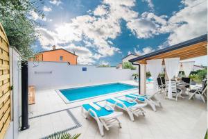 eine Terrasse mit Pool und Stühlen in der Unterkunft Villa Silver Novigrad with private pool in Novigrad Istria