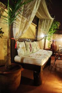 Cama en habitación con cortinas y almohadas en Riad Gallery 49 en Marrakech