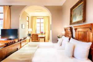 um quarto com uma cama e uma televisão num quarto em Welcome Hotel Schloss Lehen em Bad Friedrichshall