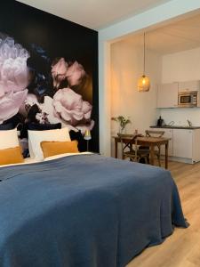 een slaapkamer met een bed met een schilderij van rozen bij De Vossenheuvel in Venlo