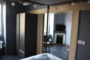 a bedroom with a bed frame and a fireplace at GITE PARIS - Appartement in La Clayette