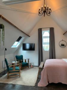 um quarto com uma cama e uma cadeira e uma televisão em De Vossenheuvel em Venlo