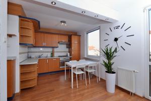 a kitchen with a table and a clock on the wall at Apartament Słoneczny 4 in Opole