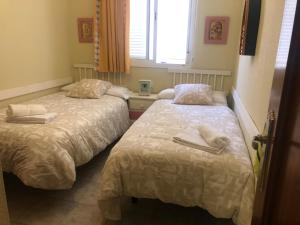 een kamer met 2 bedden en handdoeken erop bij La casa del 7 in Islantilla